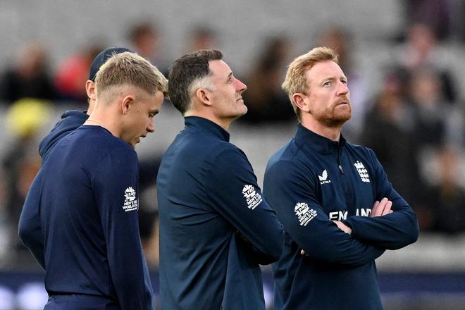 England assistant coach Michael Hussey (C) waiting for the rains to relent during the match against Australia. The match was eventually abandoned without a ball being bowled.