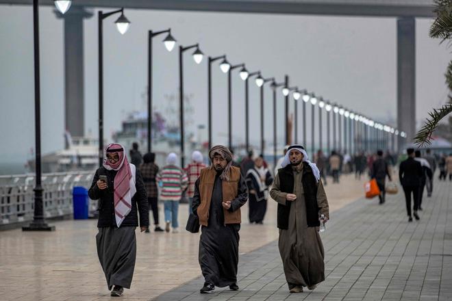 Football fans walk along the Shatt al-Arab river waterfront in Iraq’s southern city of Basra on Wednesday ahead of the Gulf Cup.