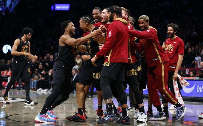 Cleveland Cavaliers guard Donovan Mitchell, front left, congratulates forward Isaac Okoro, second from front left, after making the winning basket against the Brooklyn Nets.