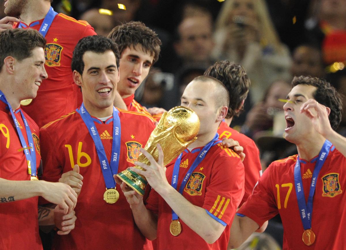 Spain’s midfielder Andres Iniesta (C) kisses the trophy as as Spain’s national football team players celebrate winning the 2010 World Cup football final Netherlands vs. Spain on July 11, 2010, at Soccer City stadium.