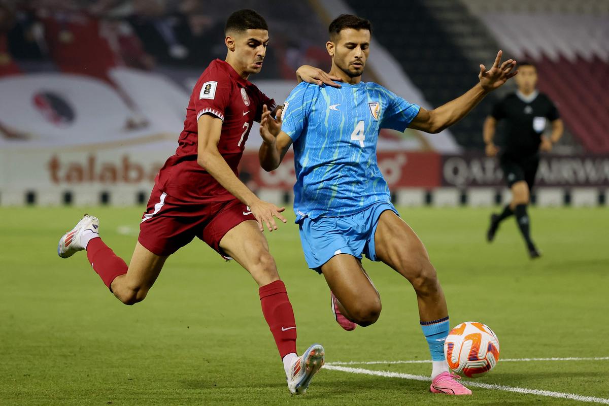 Qatar’s forward Mohamed Gouda and India’s defender Anwar Ali vie for the ball.