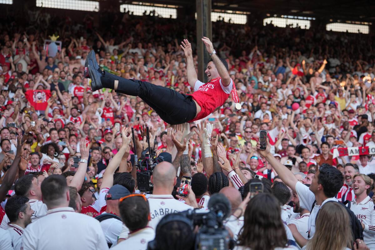 Hráči, ktorí oslavujú titul v Premier League, vyhodia do vzduchu manažéra Arsenalu Mikela Artetu.