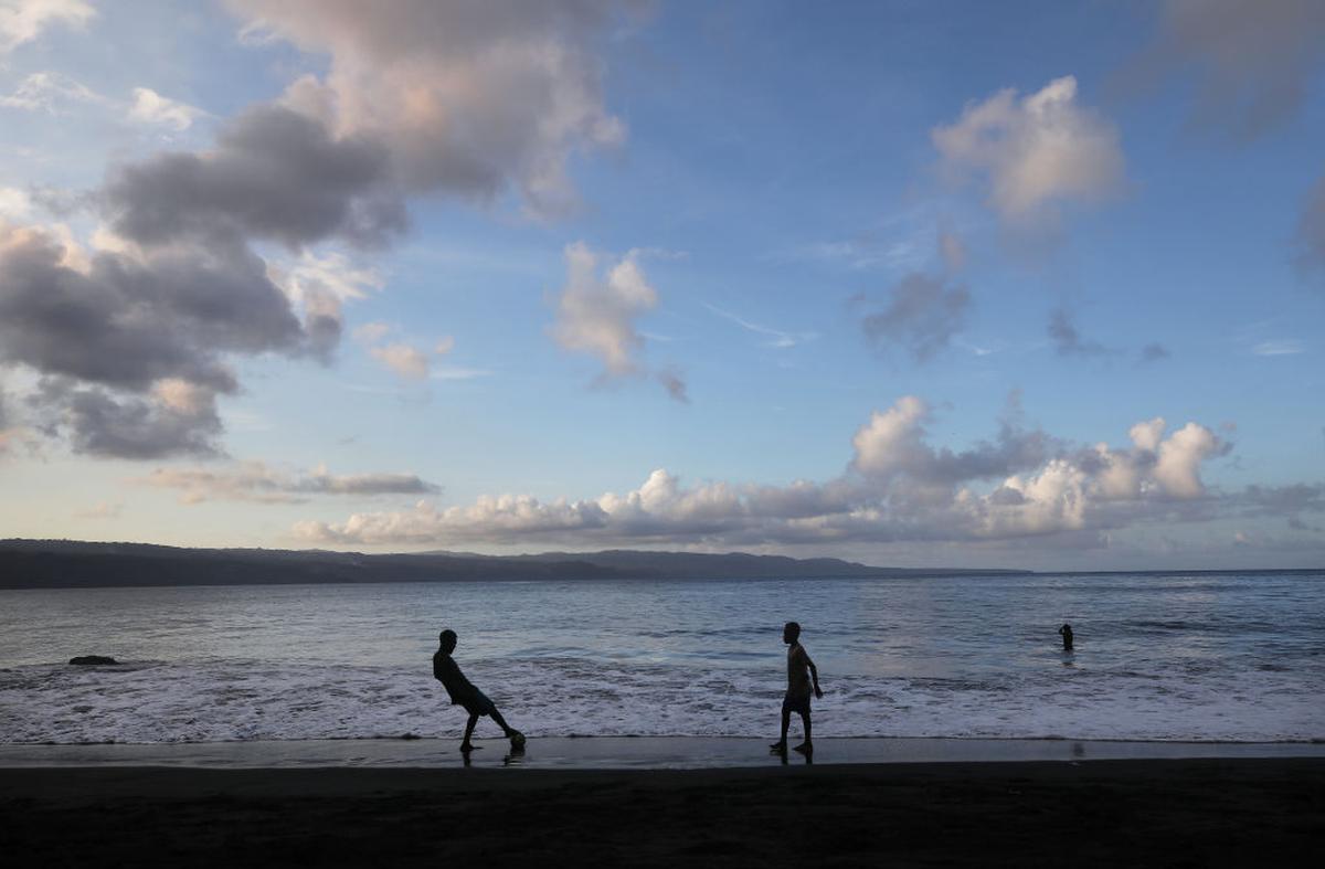 Young villagers play soccer on the black sand beach in the village of Waisisi in Tanna, Vanuatu.