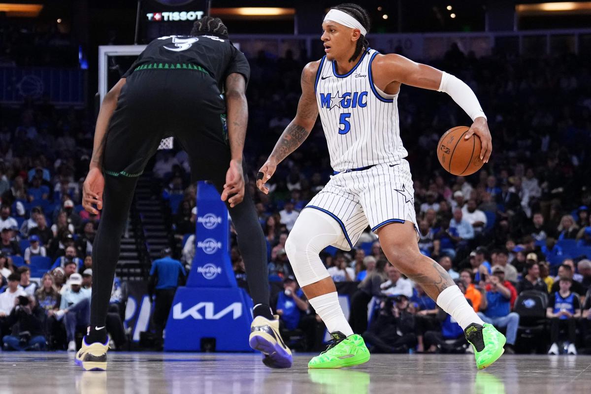 Paolo Banchero (5) do Orlando Magic dribla a bola contra Jaden McDaniels (3) do Minnesota Timberwolves.