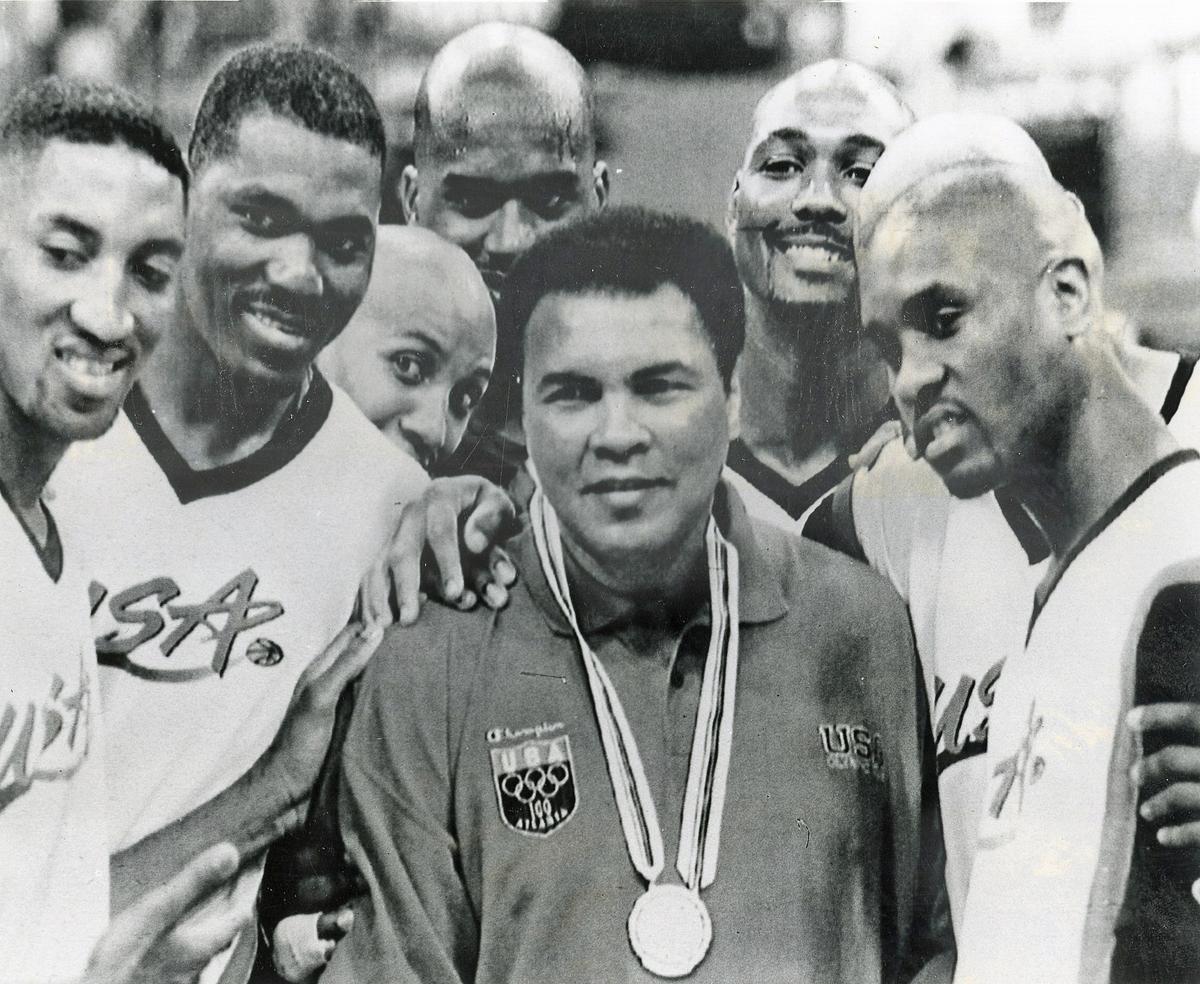 Muhammad Ali poses with the American basketball team with his gold medal. 