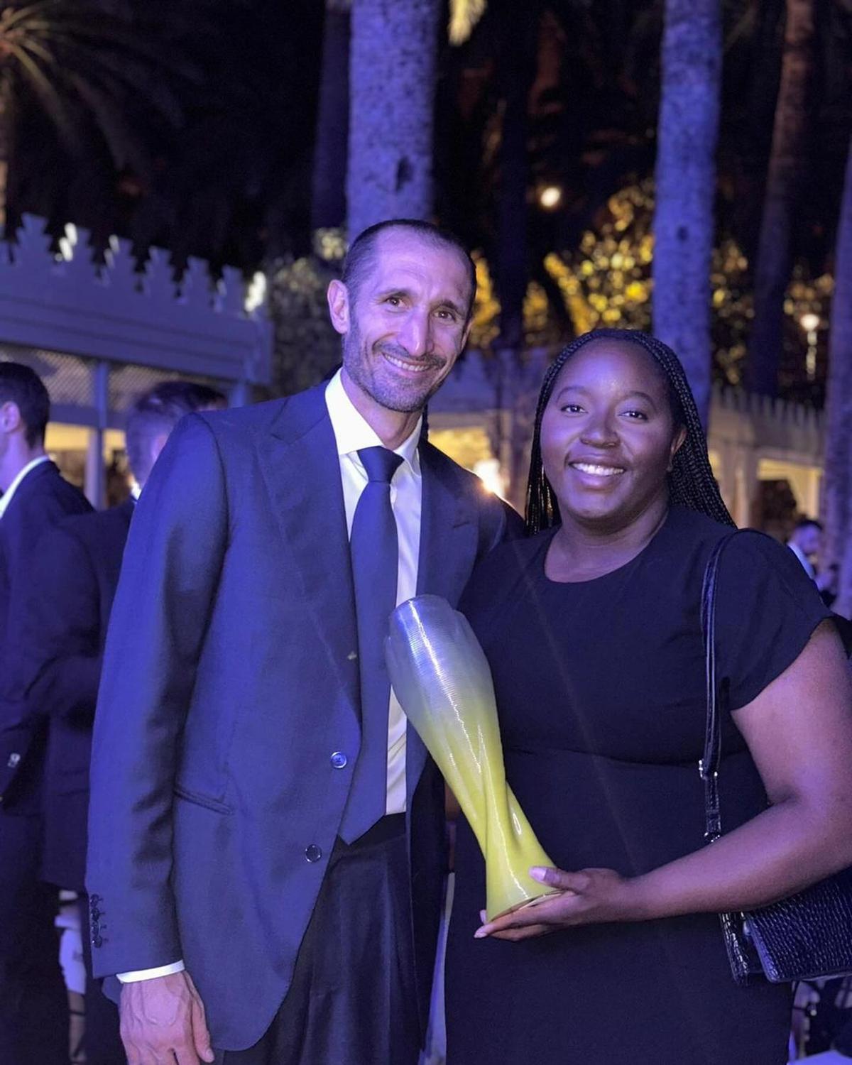 Pillar of strength: Bakenga’s sister proudly stands alongside former Italy international Giorgio Chiellini, holding the Marcus Rashford Award. She accepted the honour on Bakenga’s behalf while he was away fulfilling his ISL duties. 