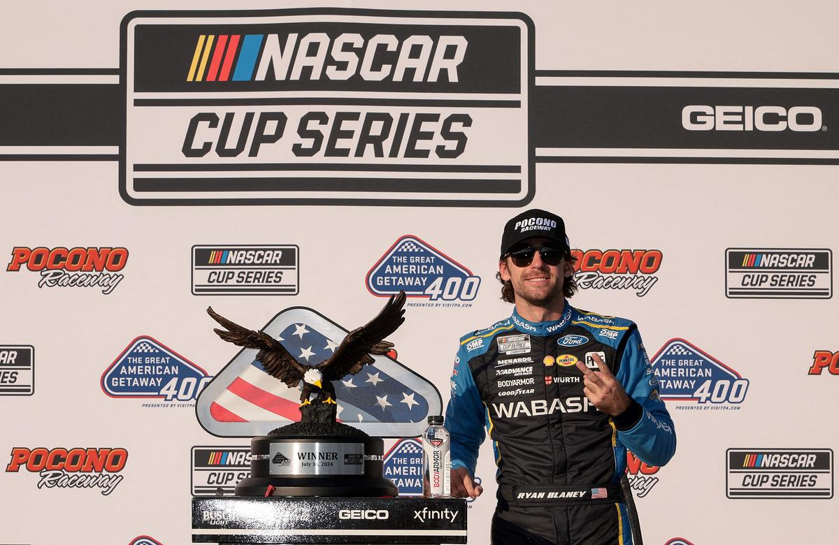 Ryan Blaney, driver of the #12 Wabash Ford, celebrates in victory lane after winning the NASCAR Cup Series The Great American Getaway at Pocono Raceway.