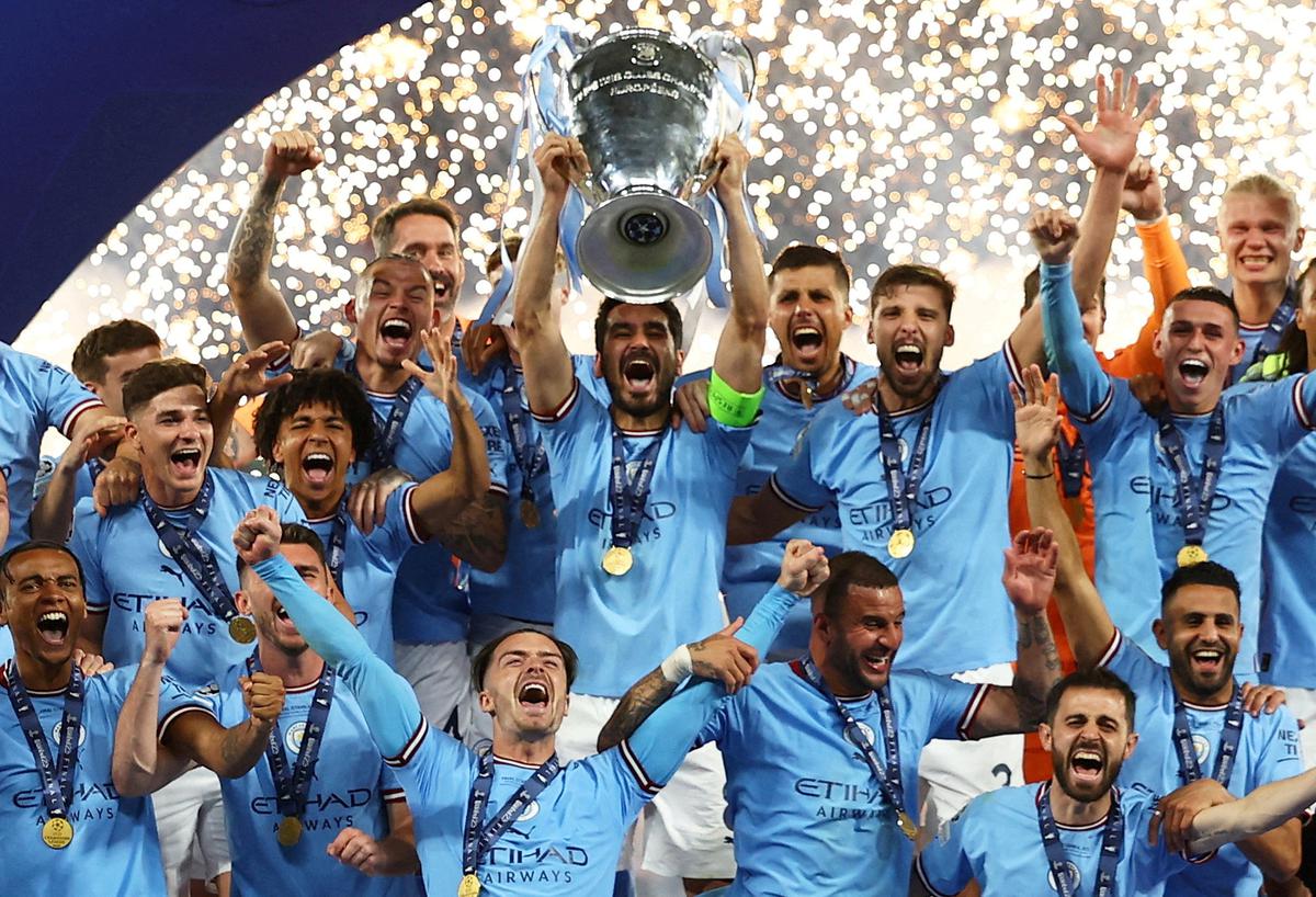 Manchester City’s Ilkay Gundogan lifts the trophy as he celebrates with teammates after winning the Champions League.