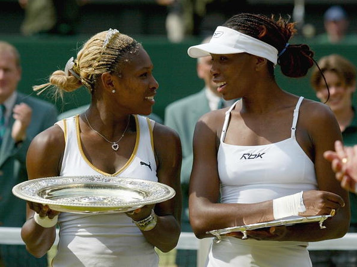 USA’s Serena Williams (left) celebrates with the trophy after beating her sister Venus Williams (right) in the Wimbledon final on July 6, 2002. 