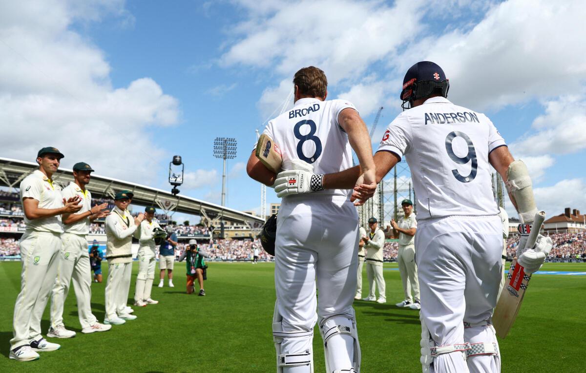 England’s Stuart Broad is pushed ahead by James Anderson to receive a guard of honour from the Australian players as he takes to the field before the start of the day’s play. 