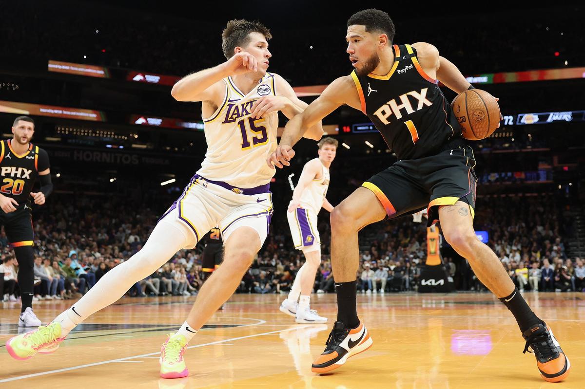 Devin Booker #1 of the Phoenix Suns handles the ball against Austin Reaves #15 of the Los Angeles Lakers during the second half of the Emirates NBA Cup game at Footprint Center in Phoenix, Arizona.