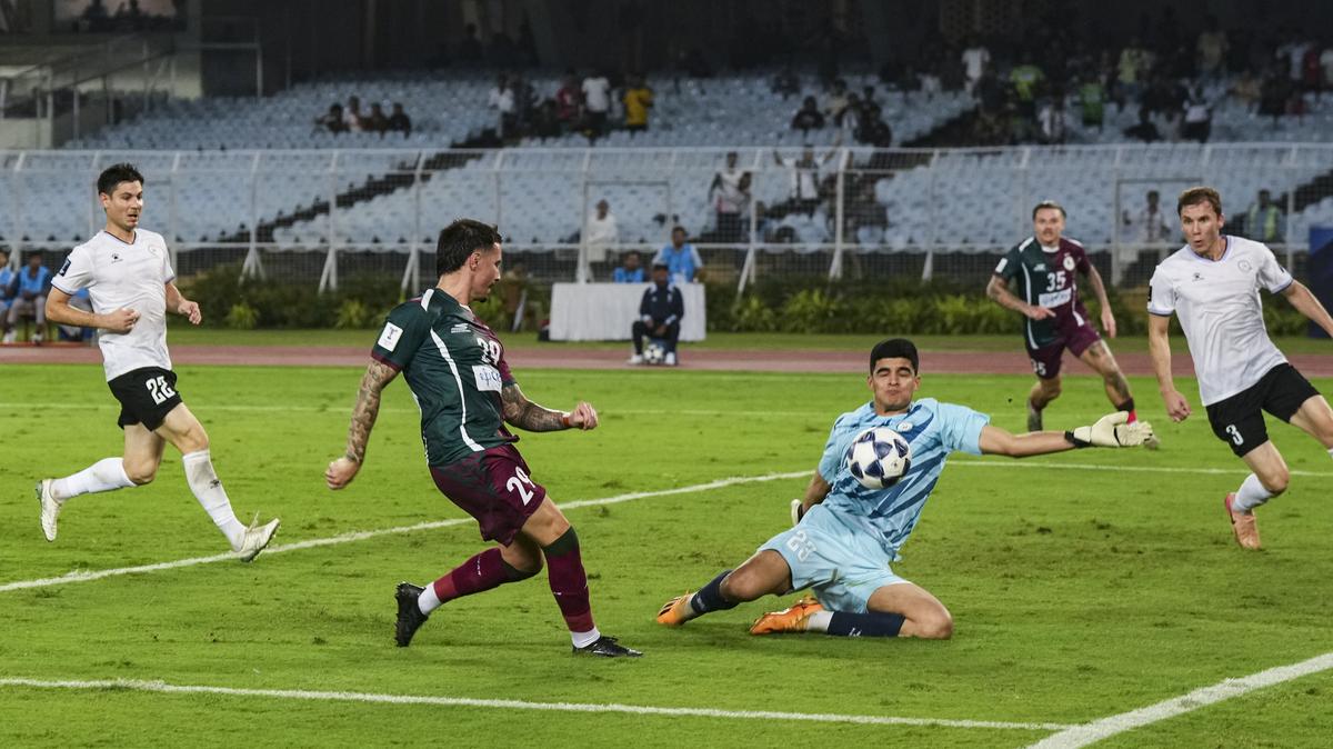 Brankár Ahal FK Kakageldi Berdiyew blokuje výstrel Jamie Maclaren od Mohuna Bagana.