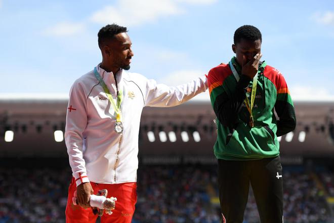 Silver medallist Matthew Hudson-Smith of England comforts gold medalist Muzala Samukonga of Zambia during the medal ceremony for the men’s 400m final on Sunday. 