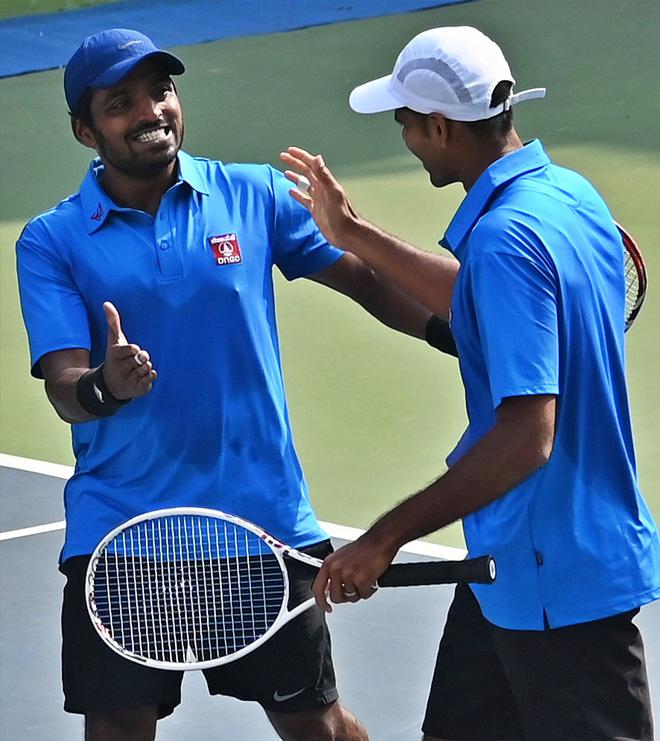 VM Ranjeet and Vishnu Vardhan celebrate their win over Asian
Games gold medallists Rohan Bopanna and Divij Sharan in the PSPB
tennis tournament in Delhi on Wednesday. 
