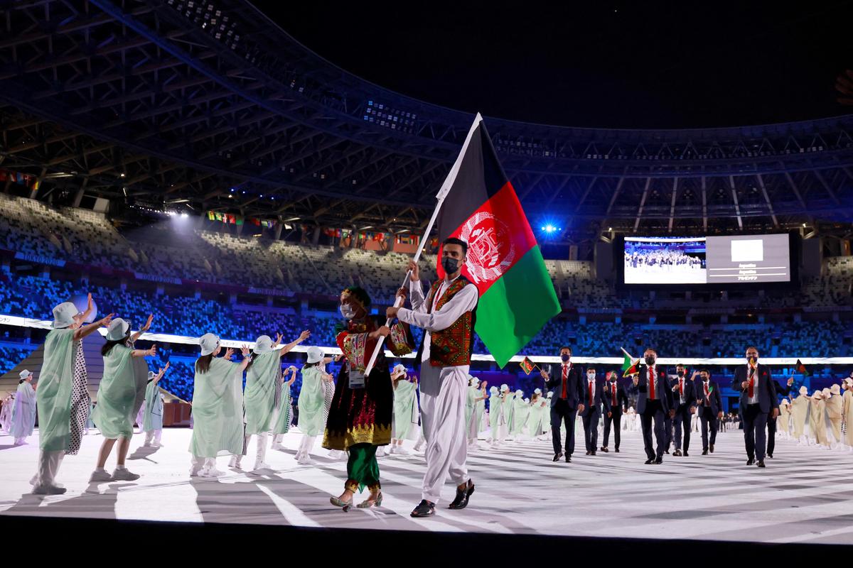 Kimia Yousofi (L) was one of Afghanistan’s flag bearers during the opening ceremony of the Tokyo 2020 Olympic Games, at the Olympic Stadium, in Tokyo, on July 23, 2021. (Photo by Odd ANDERSEN / AFP)