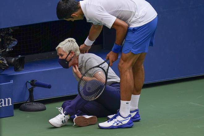 [FILE] Novak Djokovic, of Serbia, checks a linesman after hitting her with a ball in reaction to losing a point to Pablo Carreno Busta, of Spain, during the fourth round of the 2020 US Open. Djokovic defaulted the match. 
