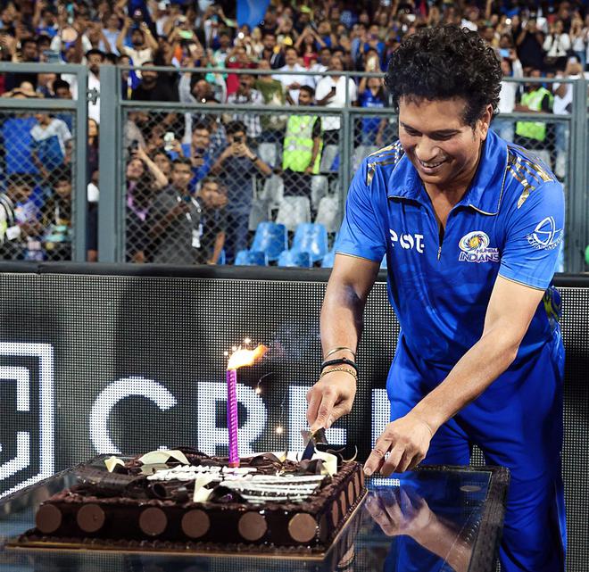 Sachin Tendulkar cuts a cake ahead of his 50th birthday at the Wankhede Stadium in Mumbai.