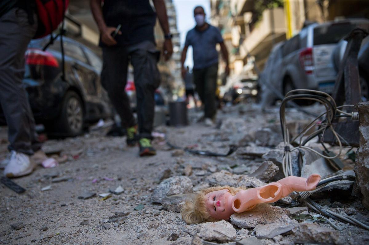 A sight of the destruction: People walk past a child’s doll that was blown out of a nearby building after a massive explosion, which occurred a day before in the capital Beirut, on August 5, 2020.