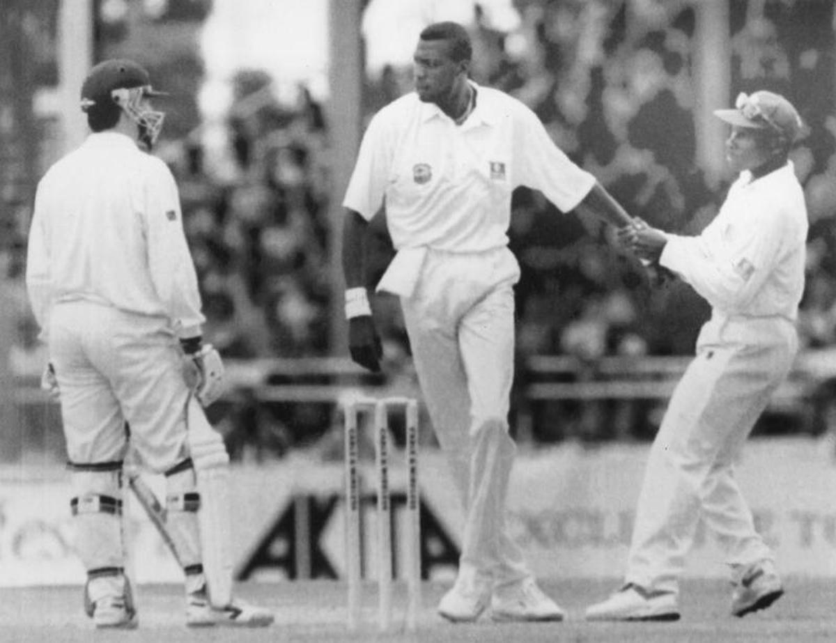 Fierce competitor: Curtly Ambrose is pulled away by skipper Richie Richardson after the bowler was involved in an altercation with Australian batsman Steve Waugh during their third Test match in Port of Spain in 1995. 