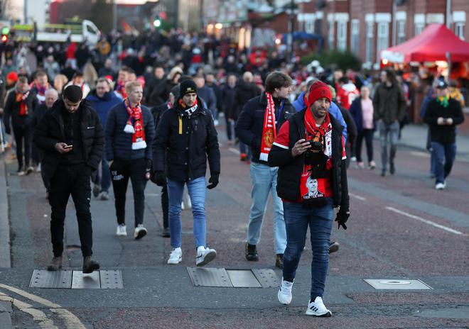 Fans arrive at the stadium prior to the UEFA Europa League knockout round play-off leg two match between Manchester United and FC Barcelona at Old Trafford.