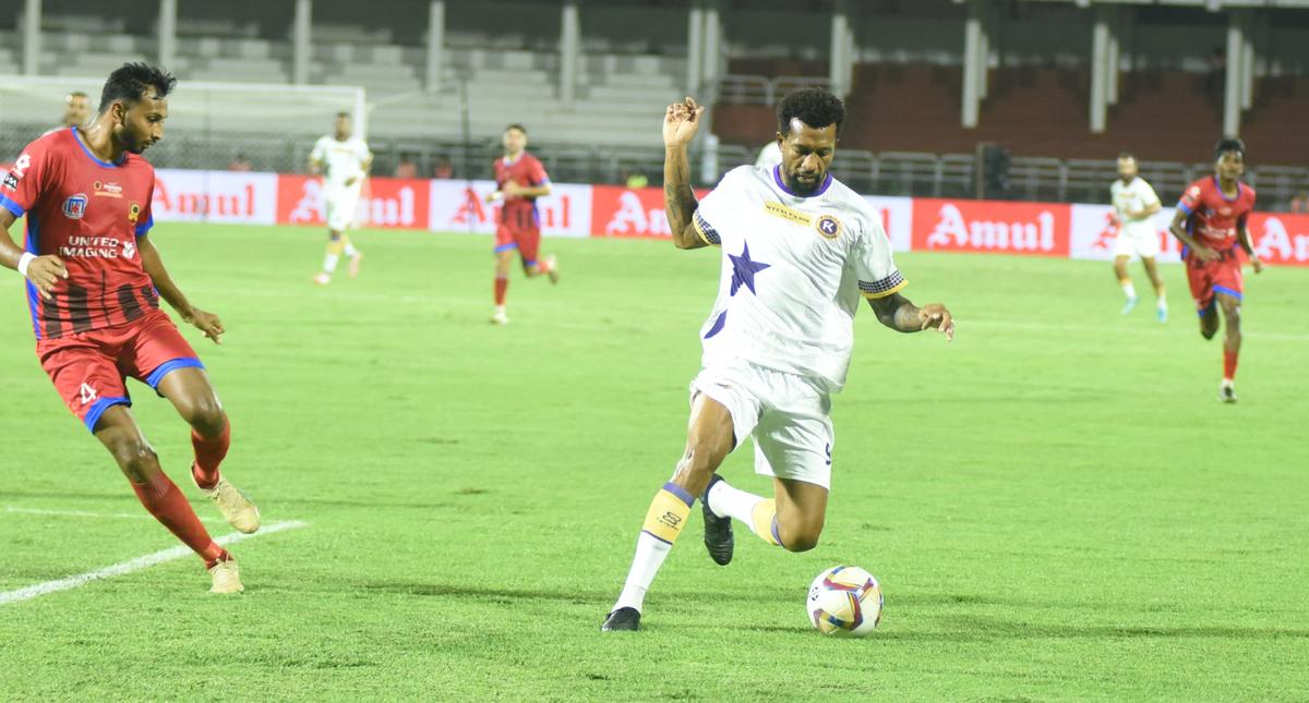 Dorielton (right) dodging defender Vikas on his way to his second goal. 