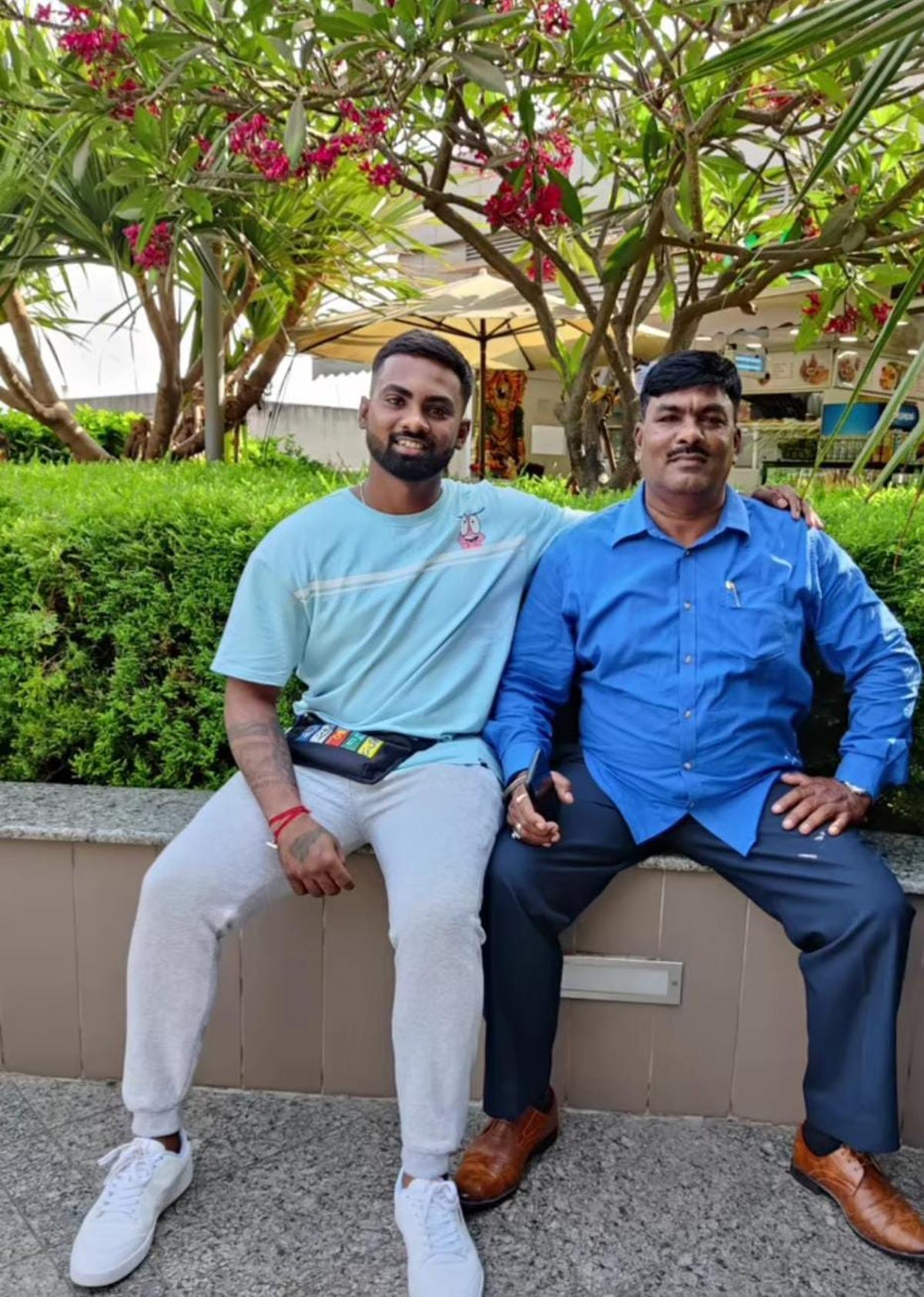 अमित त्याच्या वडिलांसोबत फोटोसाठी पोझ देतो.