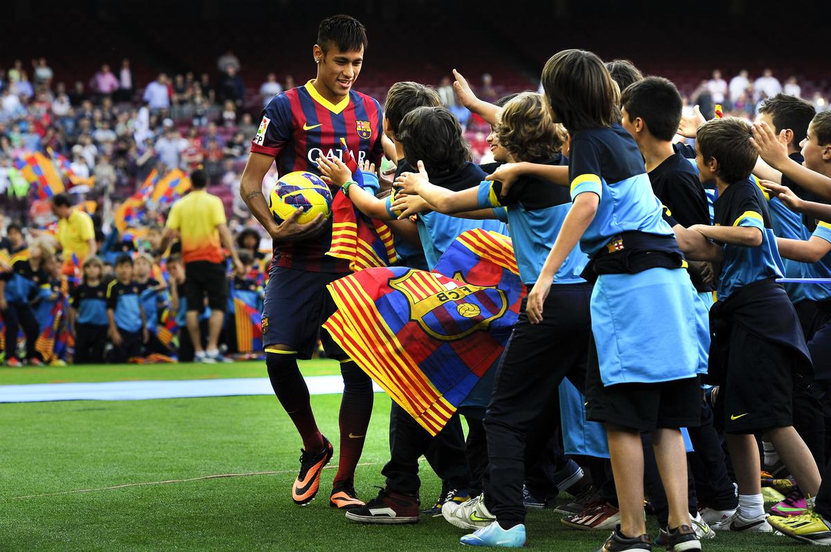 BARCELONA, SPAIN - JUNE 03:  Neymar is surrounded by children during his official presentation as a new player of FC Barcelona at Camp Nou Stadium on June 3, 2013 in Barcelona, Spain.  (Photo by David Ramos/Getty Images)