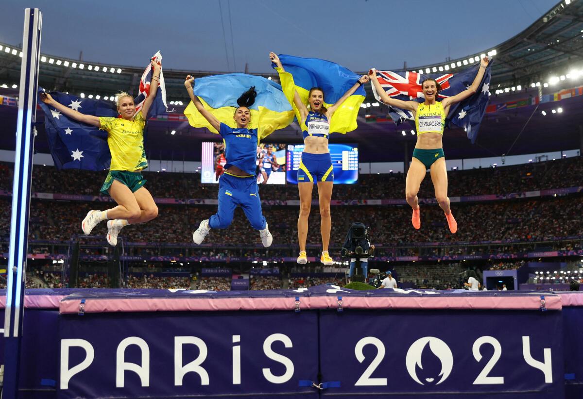 Yaroslava Mahuchikh of Ukraine celebrates with her national flag after winning gold alongside silver medallist Nicola Olyslagers of Australia and bronze medallist’s Iryna Gerashchenko of Ukraine and Eleanor Patterson of Australia. 