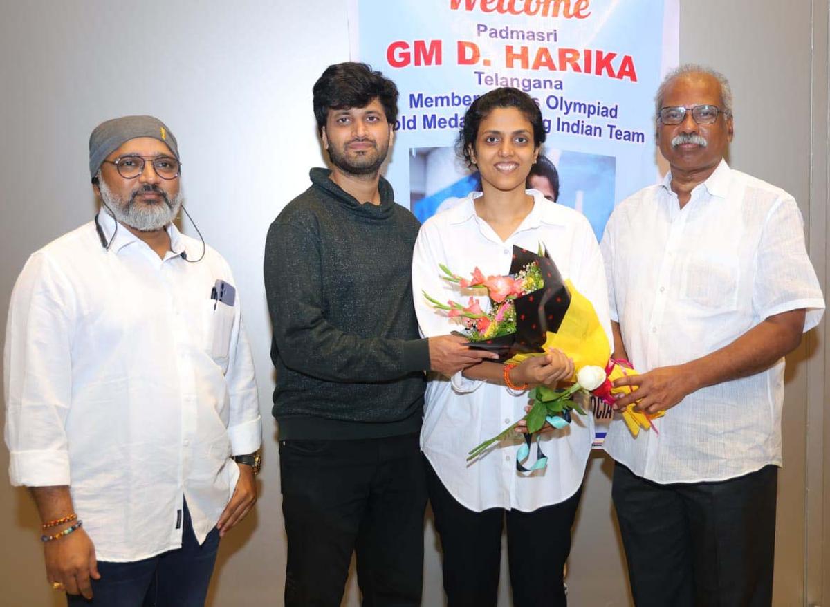 Harika’s coach N. V. S. Rama Raju, husband Karteek Chandra and TSCA president K.S. Prasad welcoming the Olympiad gold medallist in Hyderabad on Tuesday.