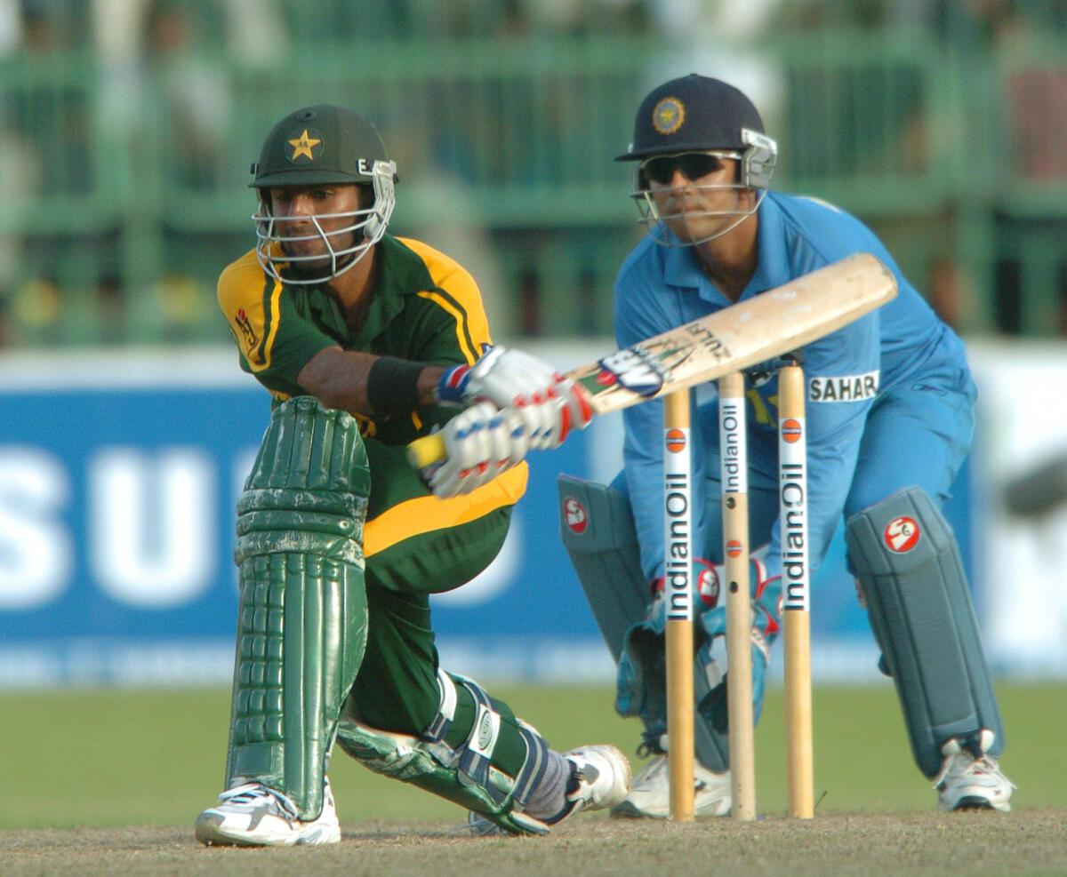 Pakistan batter Shoaib Malik attempts a reverse sweep off the bowling of Sachin Tendulkar as wicket-keeper Rahul Dravid looks on during an Asia Cup 2004 match against India at the R. Premadasa Stadium in Colombo, on July 25, 2004. 
