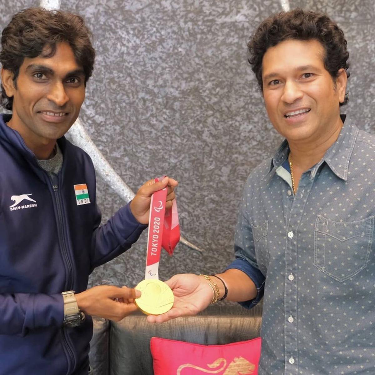 Pramod Bhagat holds the Paralympic gold medal with Sachin Tendulkar, whom he considers his idol.