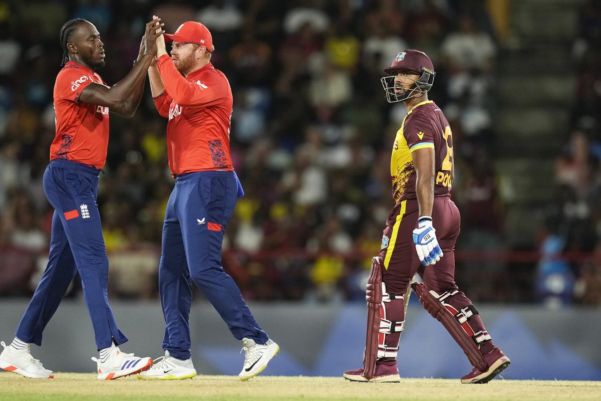 England’s Jofra Archer (left) is congratulated by teammate Jonathan Bairstow after dismissing West Indies’ Nicholas Pooran (right).