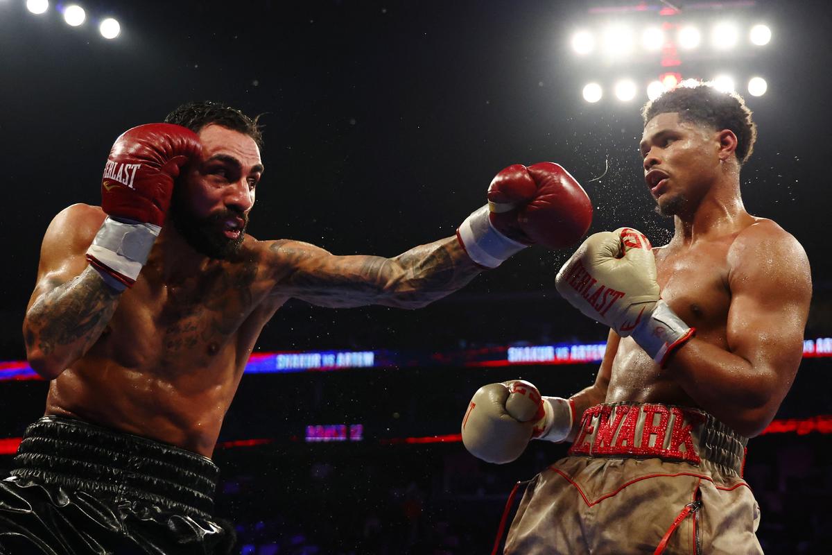 Shakur Stevenson (gold gloves) trades punches with Artem Harutyunyan of Germany (red gloves). 