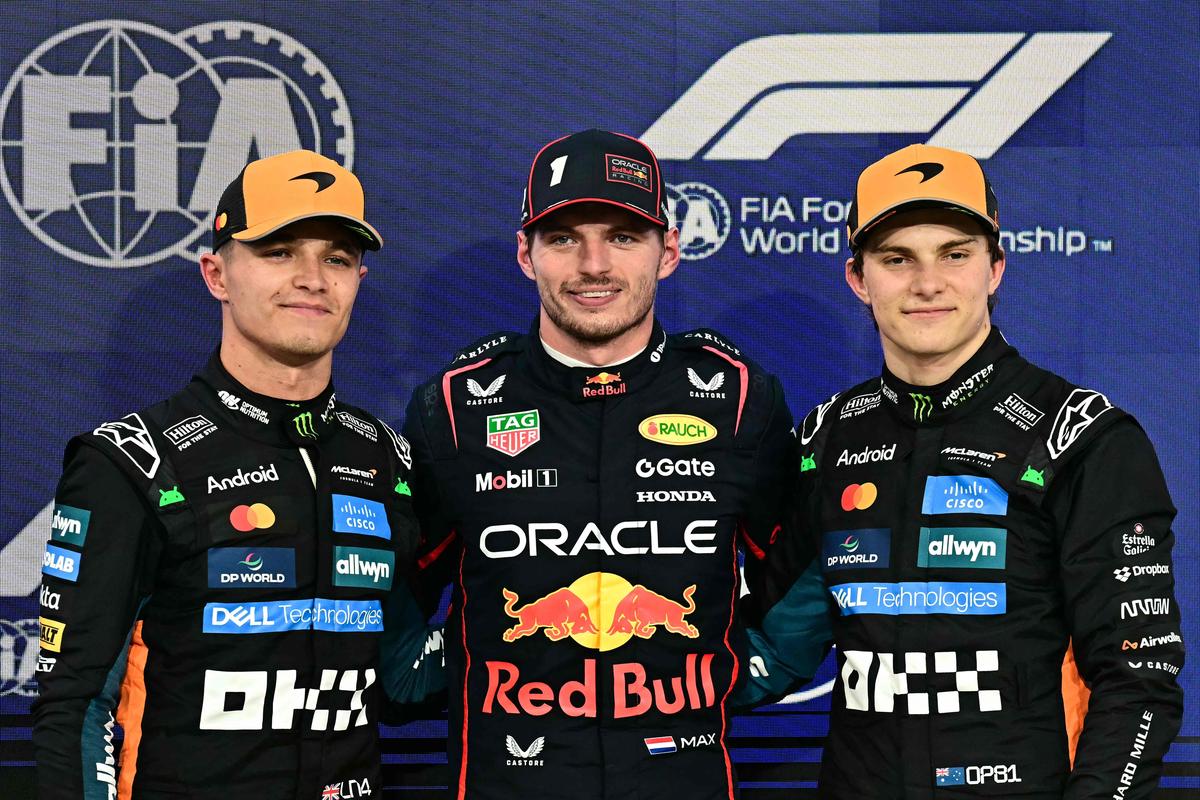 O piloto britânico da McLaren, Lando Norris, o piloto holandês da Red Bull Racing, Max Verstappen, e o piloto australiano da McLaren, Oscar Piastri, posam para uma foto após a sessão de qualificação em Abu Dhabi. 