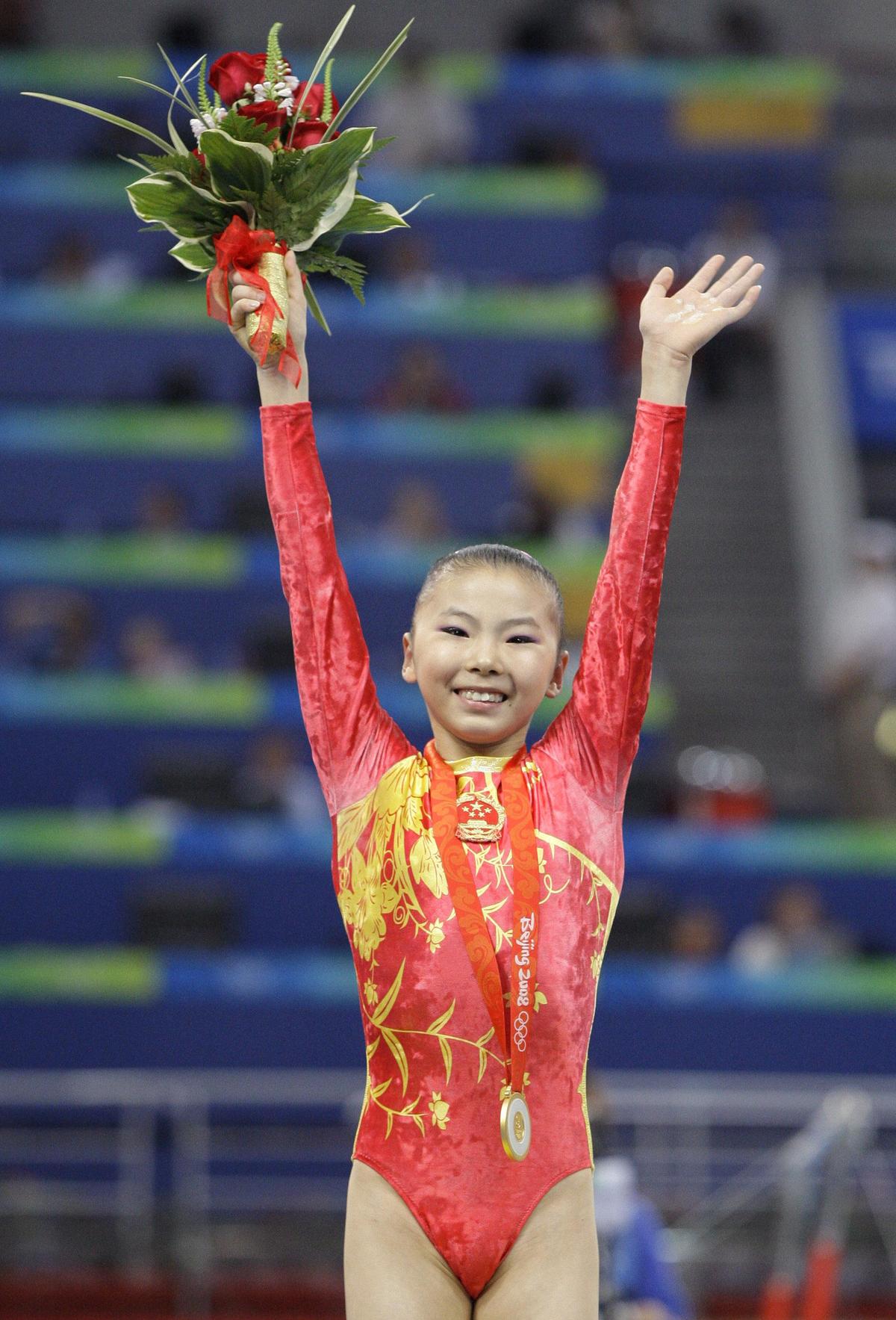 China’s gymnast gold medal winner He Kexin poses with her gold medal during the uneven bars apparatus finals at the Beijing 2008 Olympics.