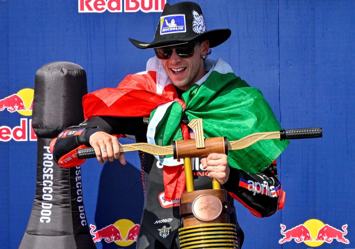 Marco Bezzecchi celebrates with his United States Grand Prix trophy.