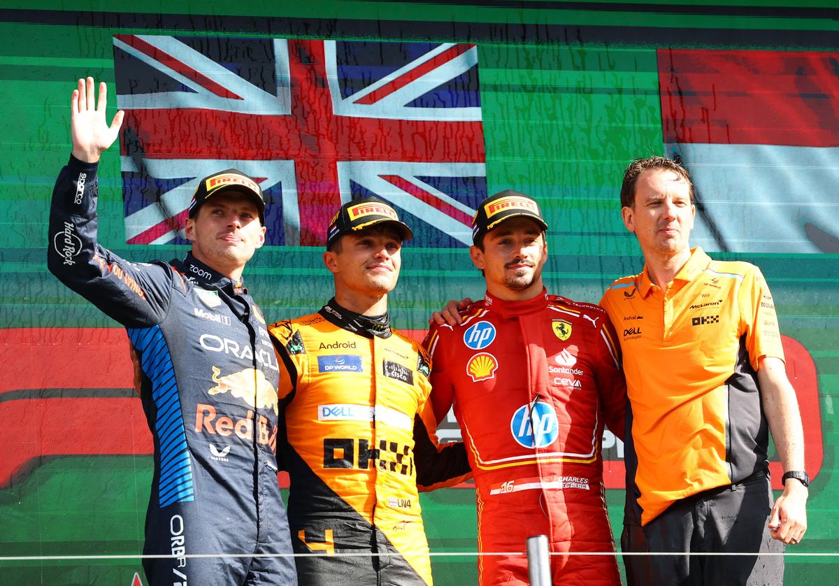 McLaren’s Lando Norris celebrates on the podium after winning the Dutch Grand Prix alongside second placed Red Bull’s Max Verstappen (Extreme L) and third placed Ferrari’s Charles Leclerc (2R).