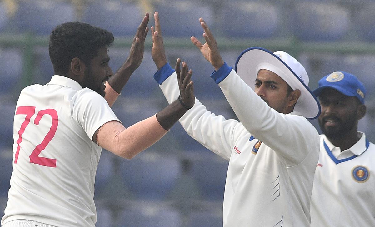 Pondicherry’s Abin Mathew (left) celebrates one of his wickets during the third day of Ranji Trophy cricket match between Delhi and Pondicherry, at Arun Jaitley Stadium in New Delhi on Sunday.