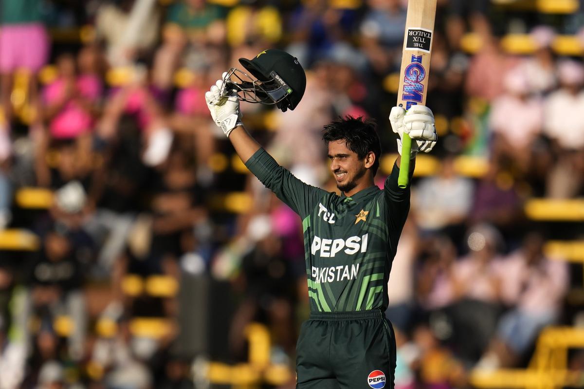 Pakistan's Saim Ayub raises his bat and hemet after reaching his century during the third International cricket match between South Africa and Pakistan, at the Wanderers stadium in Johannesburg, South Africa, Sunday, Dec. 22, 2024. (AP Photo/Themba Hadebe)