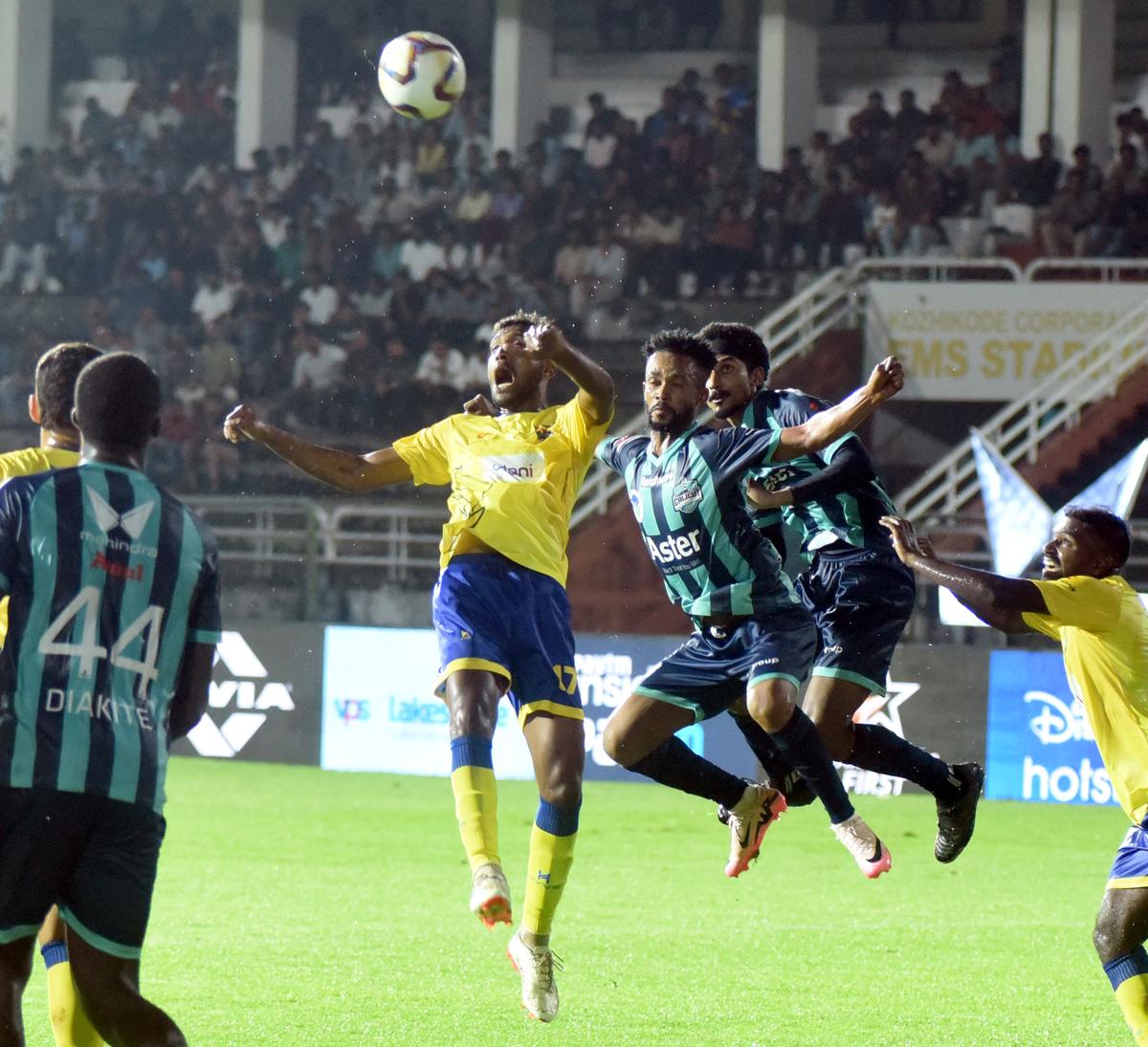 Calicut’s Richard Agyemang heading in past Kombans’ T.M. Vishnu (yellow shirt) in the Super League Kerala at Kozhikode 