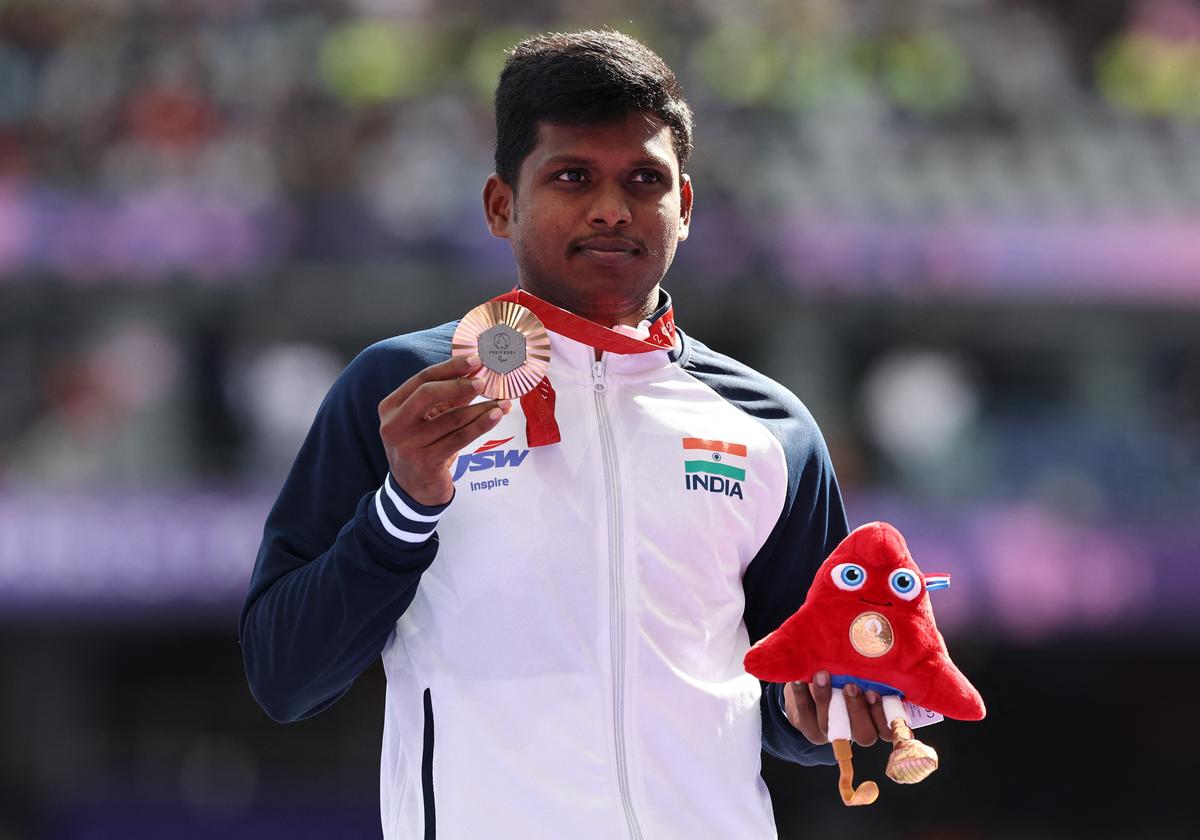 Bronze medallist Mariyappan Thangavelu of India celebrates with his medal on the podium of the Men’s High Jump T63.