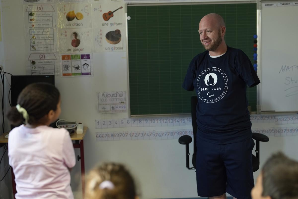FILE - Archer Matt Stutzman talks to kids during a visit to a Paris school. 