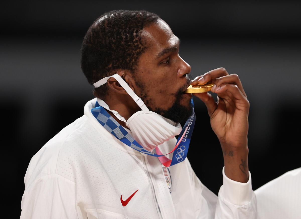 Kevin Durant of Team United States bites his gold medal during the medal ceremony for Men’s Basketball at the Tokyo 2020 Olympic Games at Saitama Super Arena on August 07, 2021 in Saitama, Japan. 