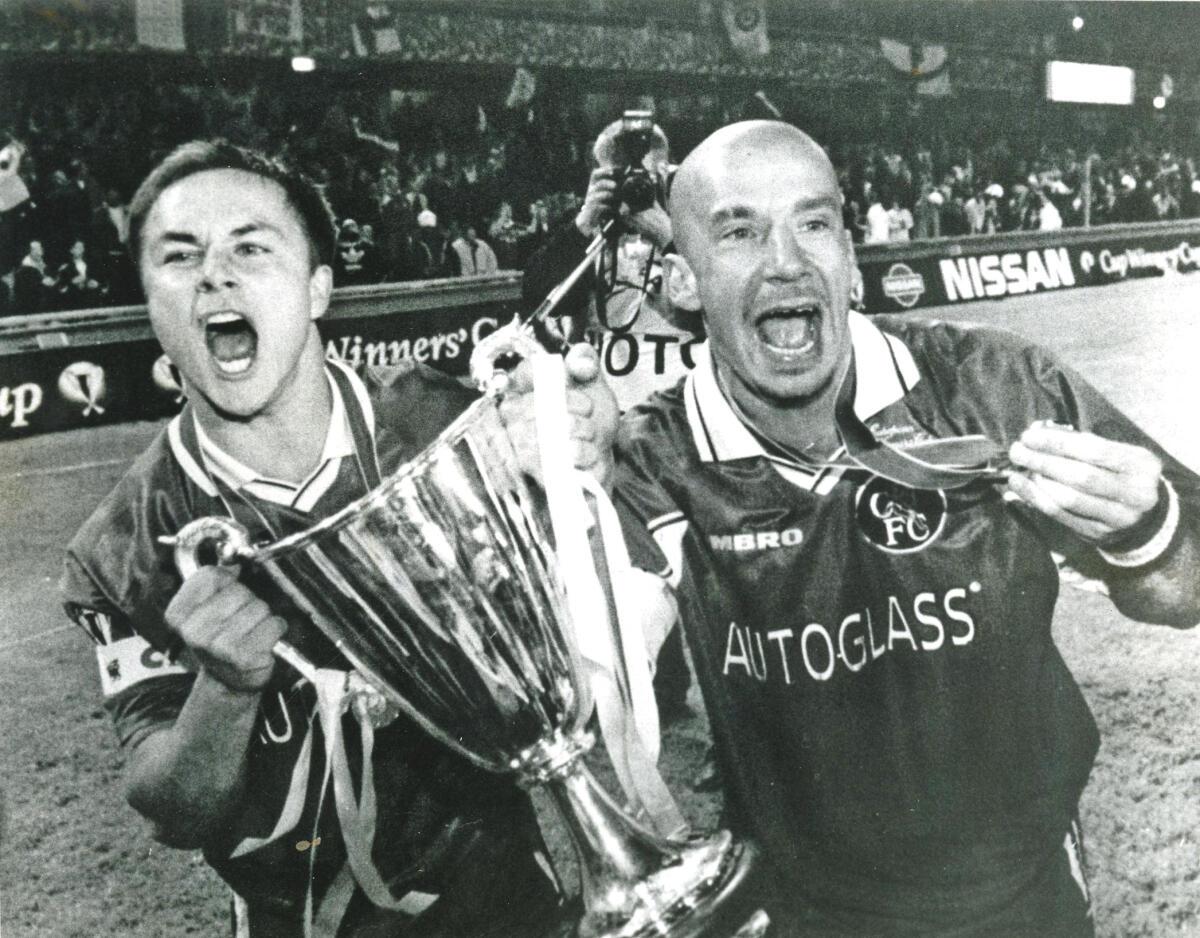 Chelsea players Dennis Wise and Gianluca Vialli hold up the winner’s cup after winning their match against VFB Stuttgart in Stockholm on May 13, 1998. 