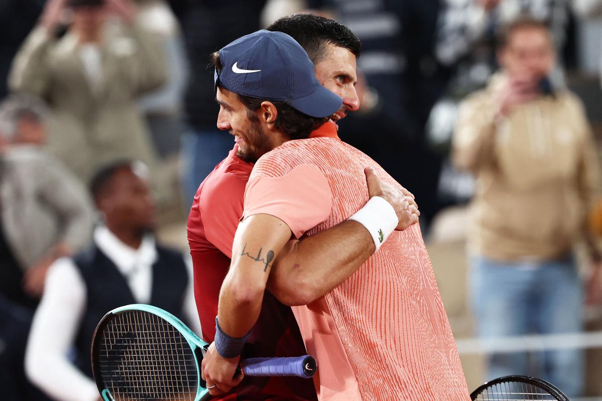 Serbia’s Novak Djokovic (L) with Italy’s Lorenzo Musetti after winning at the end of their men’s singles match. 