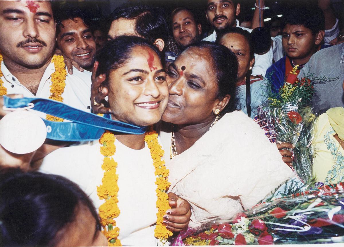 India’s Karnam Malleswari, who won the bronze medal in the women’s 69 kg division weightlifting event at the Sydney Olympics 2000, is greeted by her mother on arrival from Australia.