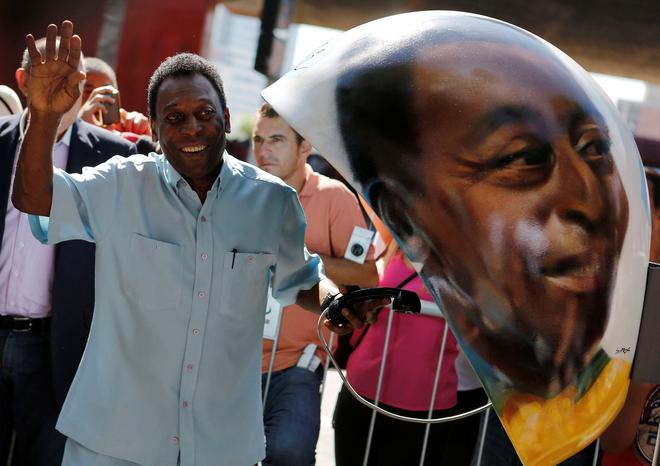 FILE PHOTO: Brazilian soccer legend Pele waves next to a public telephone booth with an image of his face painted by Brazilian artist Sipros during the Call Parade art exhibition in Sao Paulo.