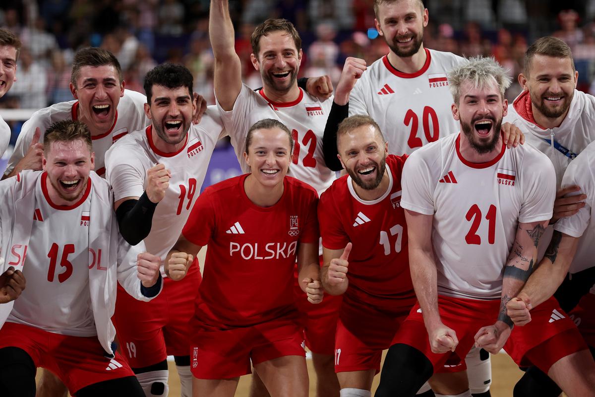 Poland’s players pose for a team photo with tennis player Iga Swiatek after the win against Slovenia.