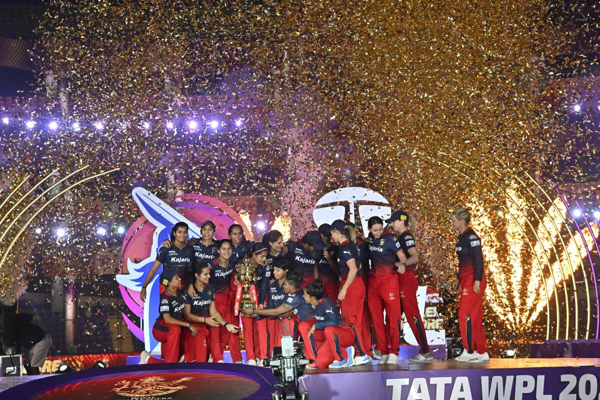 Royal Challengers Bangalore’s players hold the trophy after winning the Women‘s Premier League. 