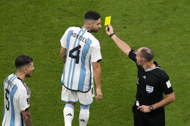 Referee Antonio Mateu shows a yellow card to Argentina’s Gonzalo Montiel during the World Cup quarterfinal soccer match between the Netherlands and Argentina.